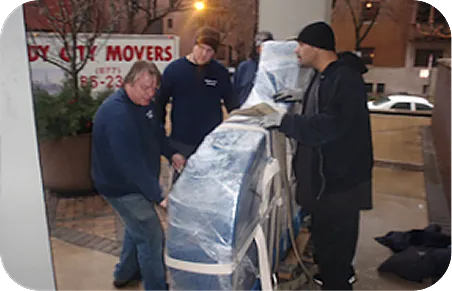 Windy City Movers crew preparing grand piano outside Chicago building