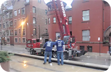 Crane hoisting grand piano up Chicago high-rise